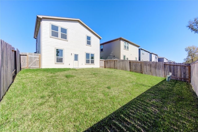 rear view of property featuring a lawn