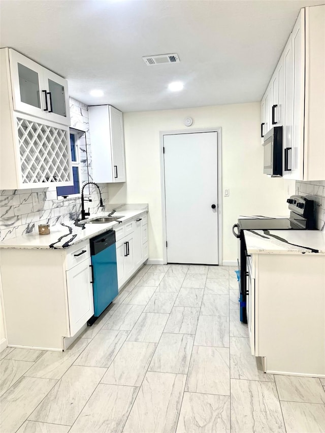 kitchen featuring white cabinets, appliances with stainless steel finishes, light stone countertops, and sink