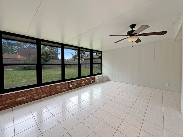 unfurnished sunroom featuring a wall mounted AC and ceiling fan