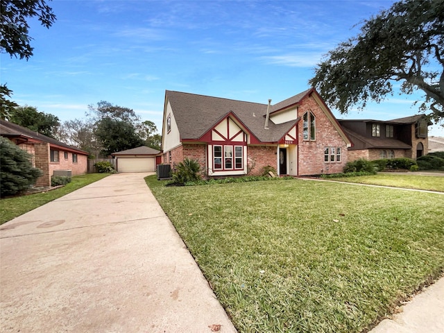 tudor home with a front yard, a garage, an outdoor structure, and central AC unit