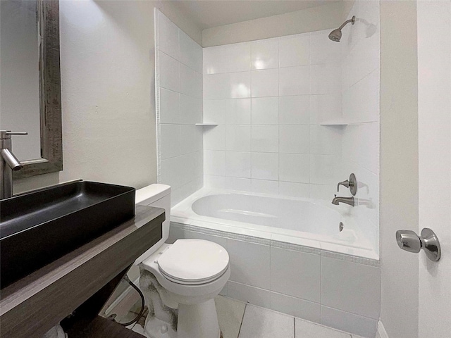 bathroom featuring tile patterned flooring, toilet, and tiled shower / bath