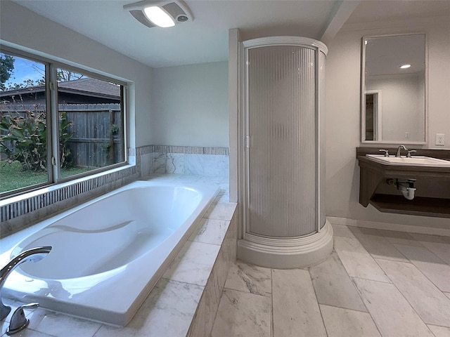 bathroom featuring sink, a healthy amount of sunlight, and plus walk in shower