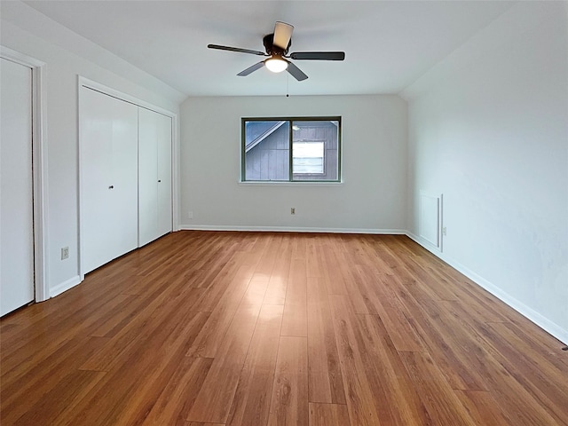 unfurnished bedroom featuring lofted ceiling, ceiling fan, and light hardwood / wood-style flooring