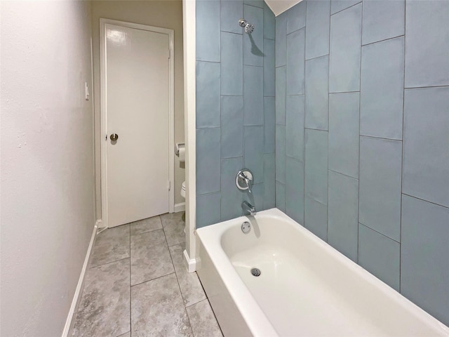 bathroom with tile patterned flooring, tiled shower / bath combo, and toilet