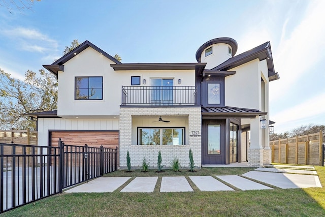 view of front of home with a front lawn, a balcony, ceiling fan, and a garage