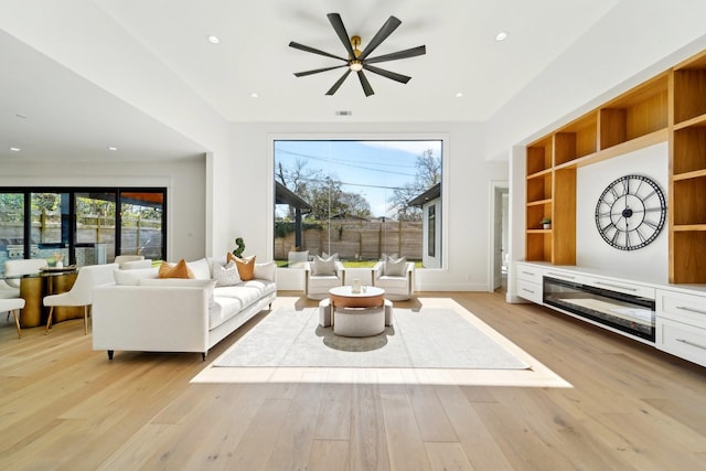 living room featuring ceiling fan, light hardwood / wood-style flooring, and a healthy amount of sunlight