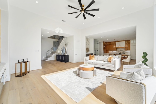 living room with ceiling fan and light hardwood / wood-style flooring