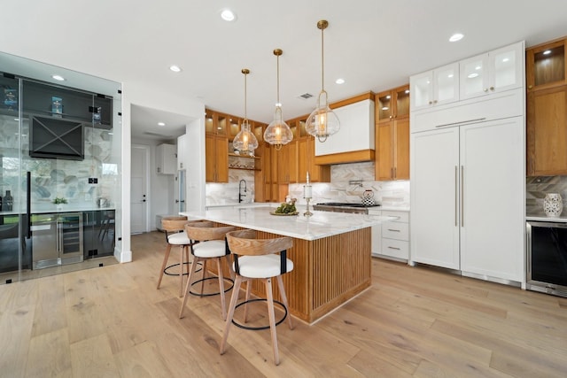 kitchen featuring light wood-type flooring, tasteful backsplash, and white cabinetry