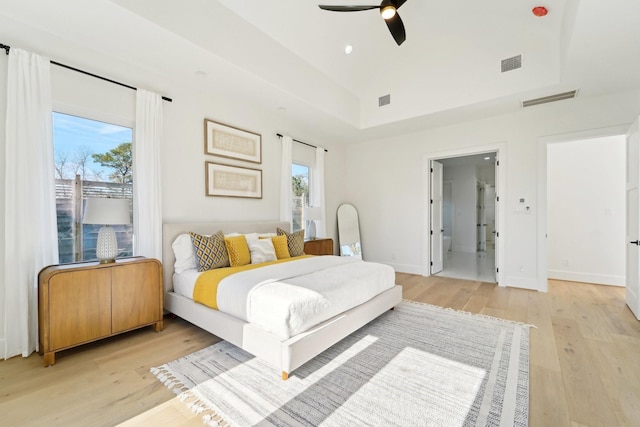 bedroom featuring ensuite bath, ceiling fan, and light wood-type flooring