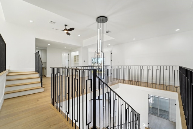 stairs with ceiling fan and wood-type flooring