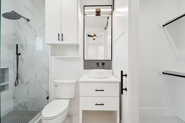 bathroom with tasteful backsplash, a tile shower, vanity, and toilet