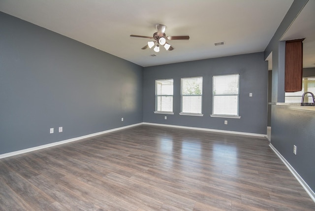 empty room featuring ceiling fan and dark hardwood / wood-style flooring