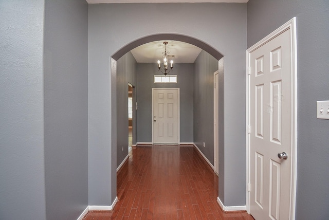 interior space with dark wood-type flooring and a chandelier