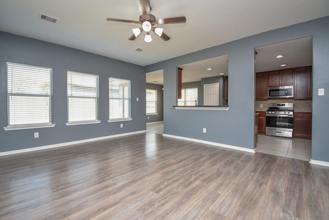 unfurnished living room featuring ceiling fan and hardwood / wood-style flooring