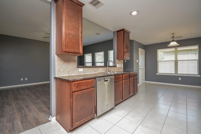 kitchen with stainless steel dishwasher, decorative light fixtures, light tile patterned floors, backsplash, and sink