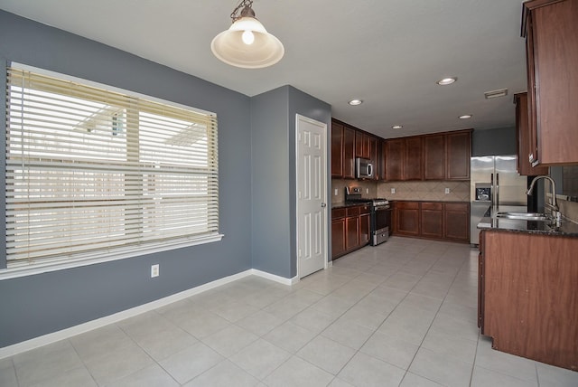 kitchen featuring stainless steel appliances, sink, decorative light fixtures, light tile patterned flooring, and tasteful backsplash