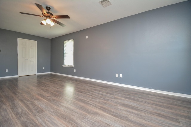 unfurnished room featuring dark wood-type flooring and ceiling fan