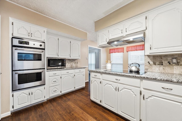 kitchen with white cabinets, decorative backsplash, and double oven