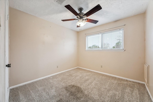 spare room featuring carpet flooring, a textured ceiling, and ceiling fan