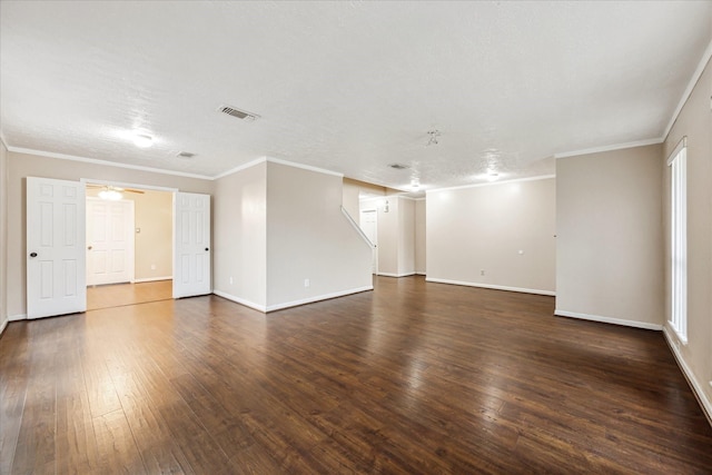 empty room with dark wood-type flooring, a textured ceiling, and ornamental molding