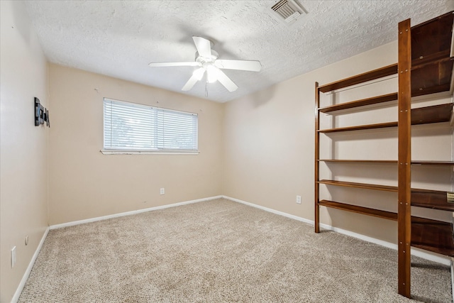 carpeted empty room featuring a textured ceiling and ceiling fan