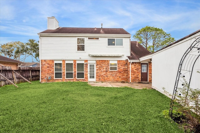 back of house with a patio and a lawn