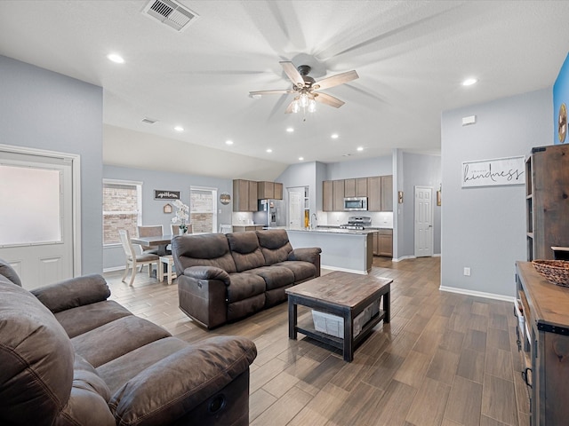 living area with a ceiling fan, recessed lighting, dark wood-style flooring, and visible vents