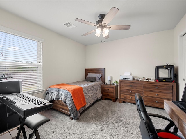 carpeted bedroom featuring visible vents and a ceiling fan