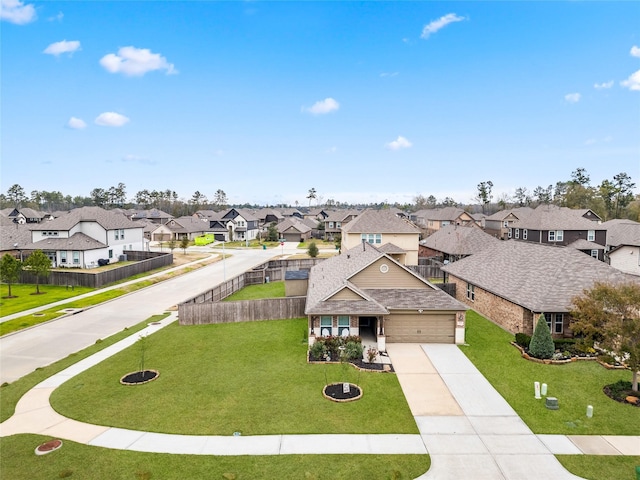 view of front facade with an attached garage, driveway, a front yard, and a residential view