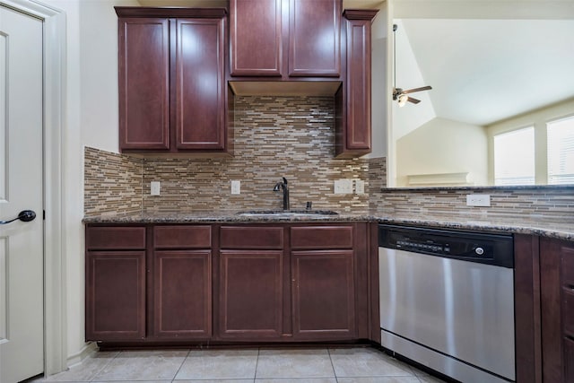 kitchen featuring stainless steel dishwasher, vaulted ceiling, tasteful backsplash, dark stone countertops, and sink