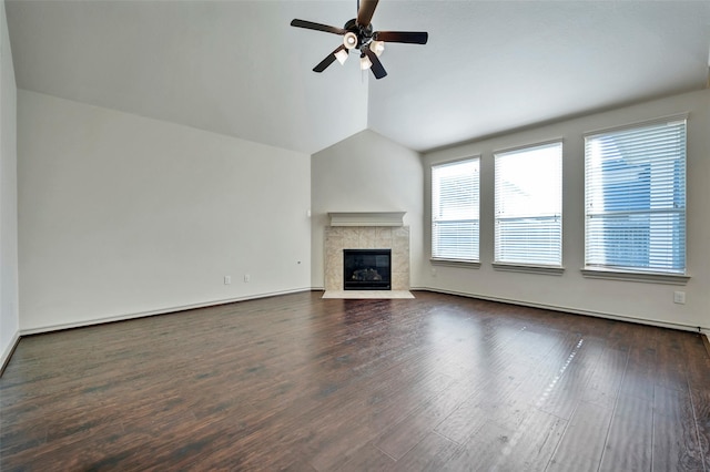 unfurnished living room featuring ceiling fan, a tile fireplace, vaulted ceiling, and dark wood-type flooring