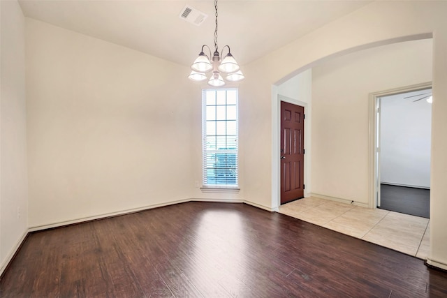 unfurnished room featuring a chandelier and light hardwood / wood-style flooring