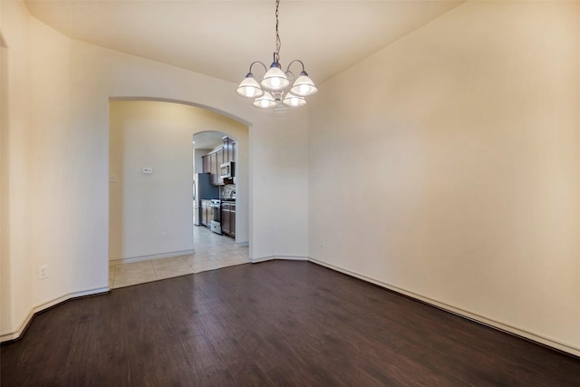 unfurnished room with light hardwood / wood-style flooring and a chandelier