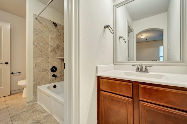 full bathroom featuring toilet, vanity, and tiled shower / bath