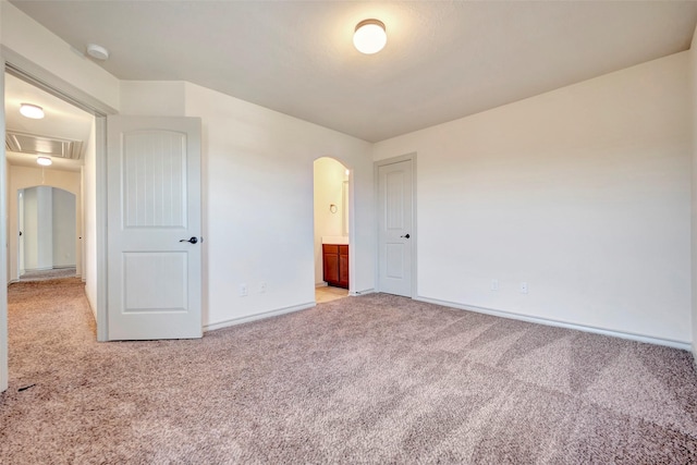 unfurnished bedroom with connected bathroom and light colored carpet