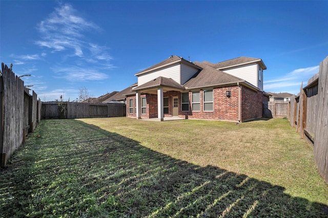 rear view of house with a yard and a patio area