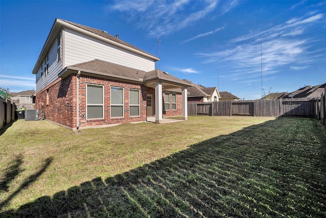 back of property with central air condition unit and a lawn