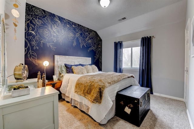 bedroom with lofted ceiling, visible vents, an accent wall, a textured ceiling, and baseboards