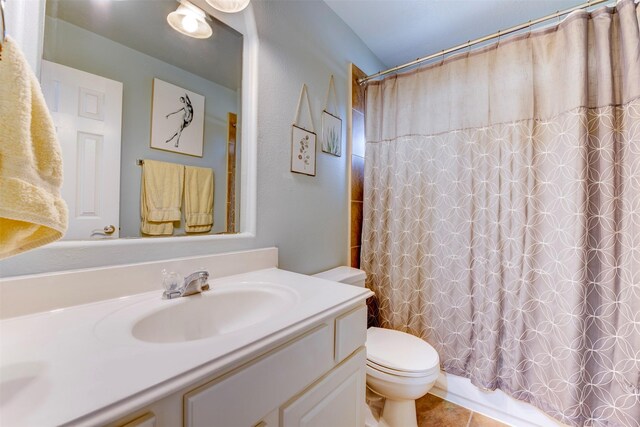 full bathroom with tile patterned flooring, shower / bath combo with shower curtain, vanity, and toilet