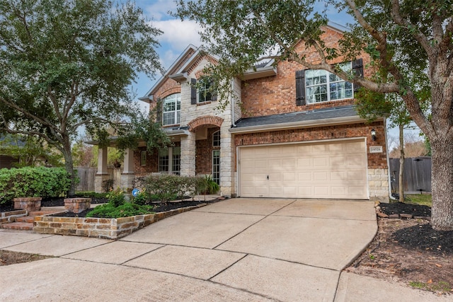 craftsman house featuring a garage, stone siding, driveway, and fence