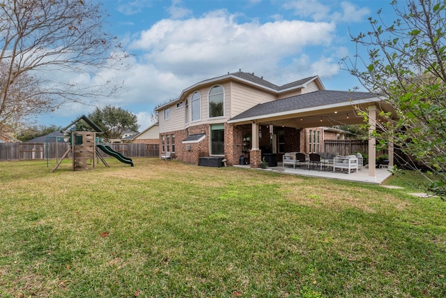 rear view of property with brick siding, a lawn, a playground, and a patio