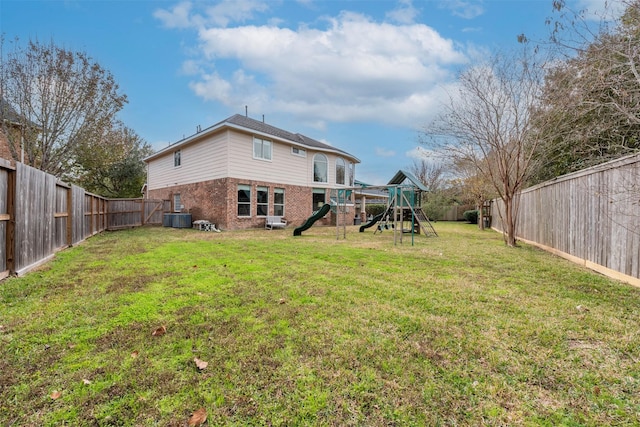 rear view of property featuring cooling unit, a playground, and a lawn