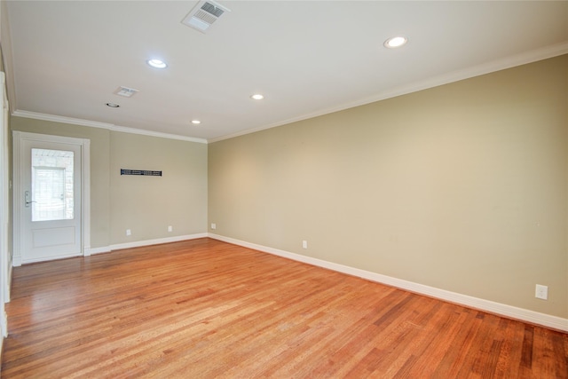 spare room with light wood-type flooring and crown molding