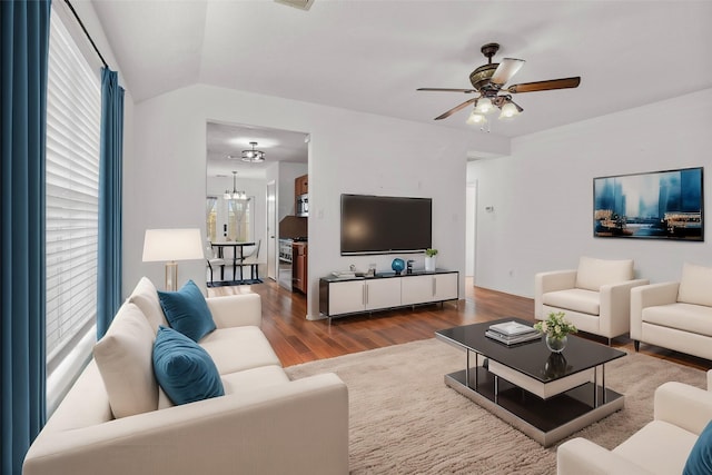 living room featuring ceiling fan with notable chandelier, vaulted ceiling, and hardwood / wood-style floors