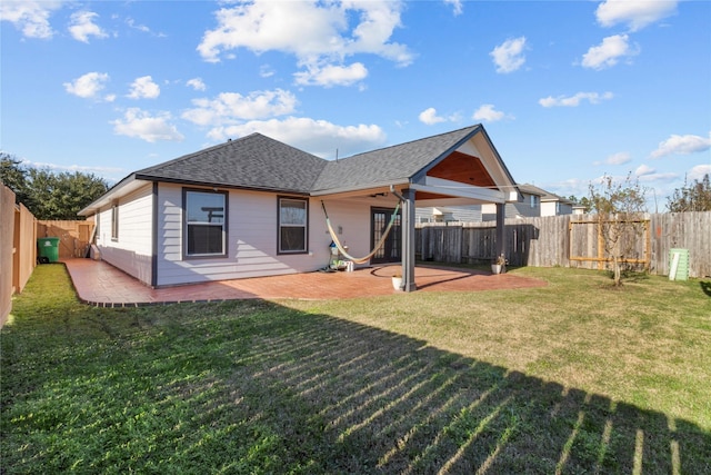 back of property with a lawn and a patio