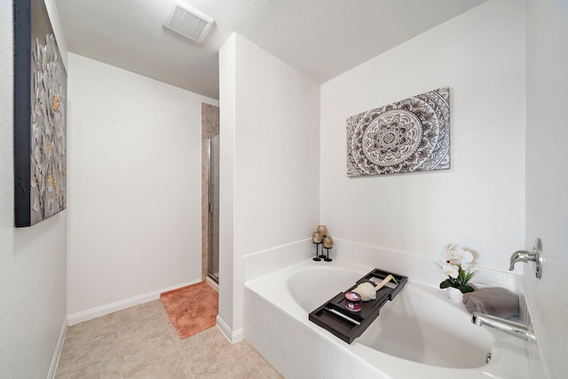 bathroom with a textured ceiling and separate shower and tub