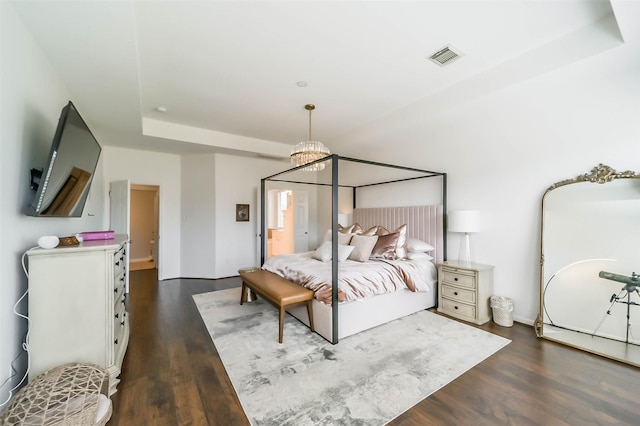 bedroom featuring dark hardwood / wood-style floors and a tray ceiling