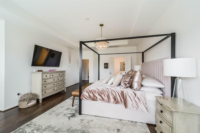 bedroom with a notable chandelier and dark hardwood / wood-style flooring