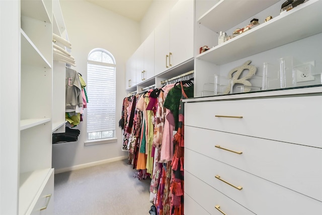 walk in closet featuring light colored carpet