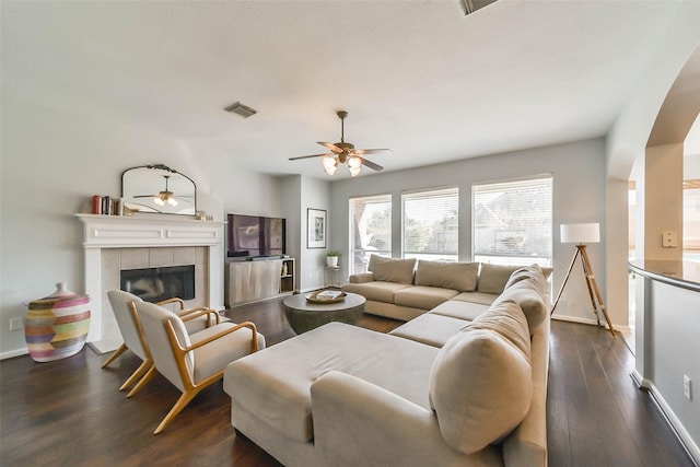 living room with ceiling fan, dark hardwood / wood-style floors, and a fireplace